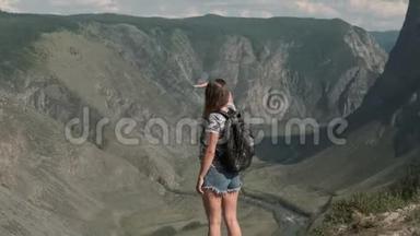 女旅行者带着背包<strong>站在山顶</strong>上，看着前方